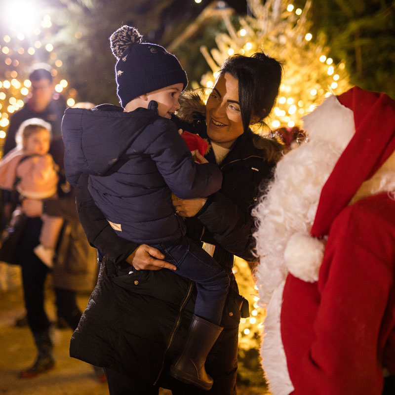 Child with parent meeting Santa in Santa's Grotto.