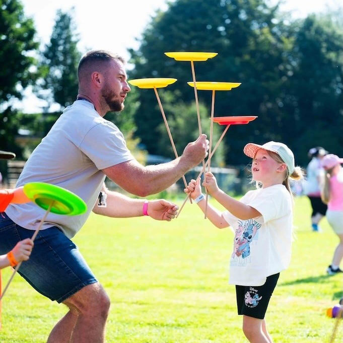 Man teaching kids to juggle plates