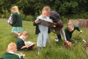 School group doing activity in meadow