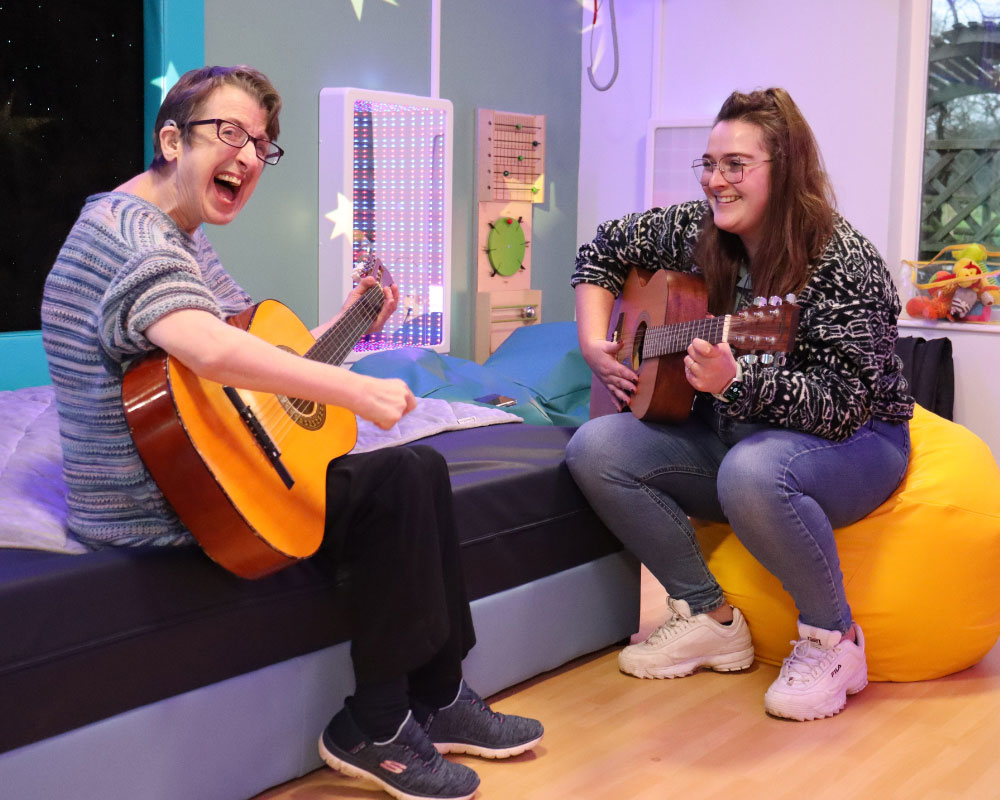2 people playing guitar in our sensory space
