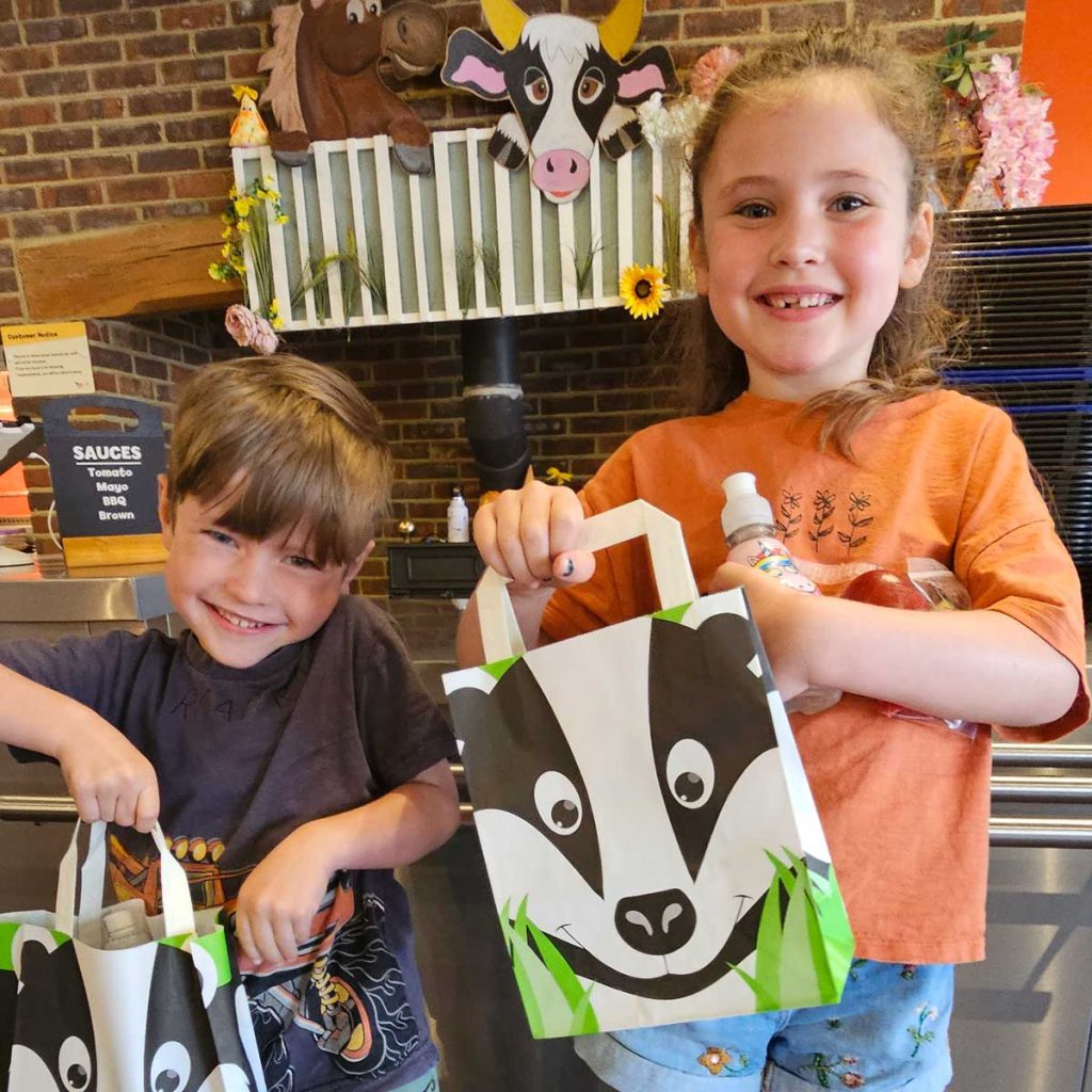 a boy and girl with animal themed kids lunch boxes