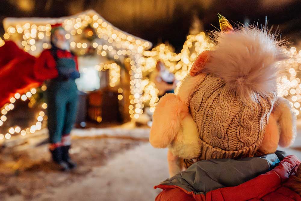 Christmas on the farm - a child in a bobble hat watching a Christmas performance.